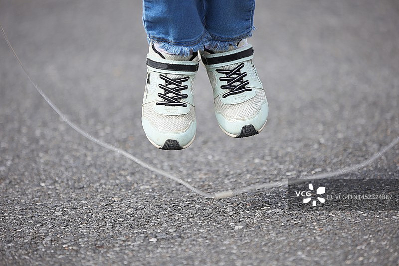 儿童玩跳绳的脚部特写图片素材