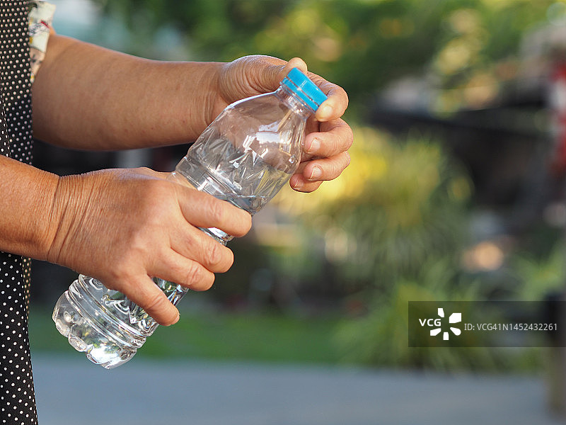 女人手触碰塑料水瓶图片素材