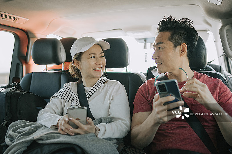 在摩洛哥SUV后座自驾游的亚洲游客夫妇图片素材