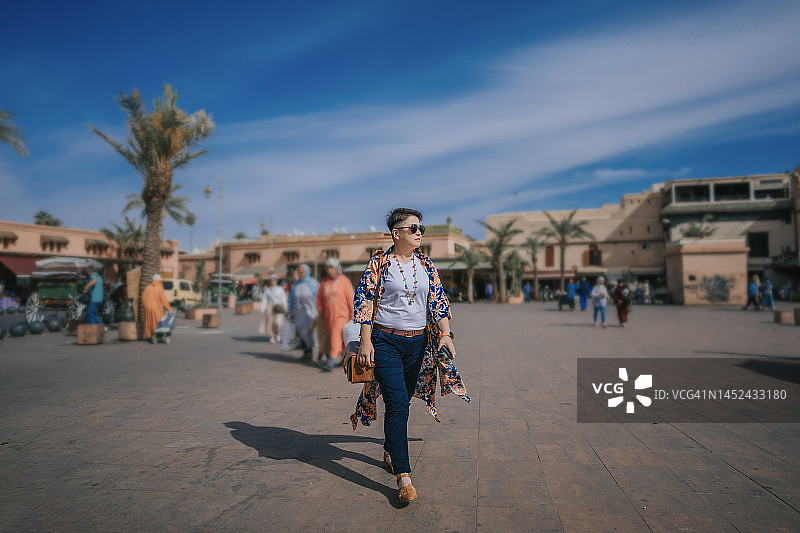 中国女性游客在摩洛哥马拉喀什的德吉玛广场散步图片素材