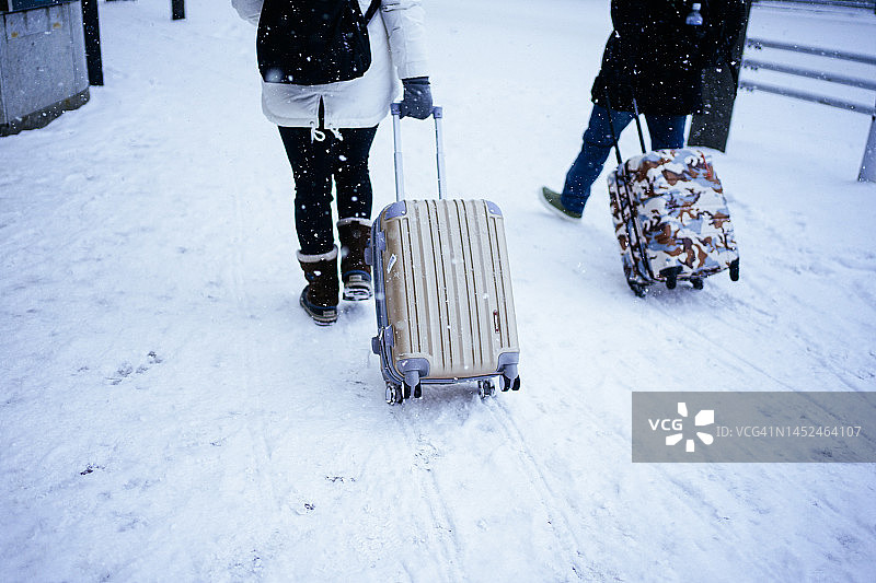 冬季札幌市北海道游客在雪地上拖着行李图片素材