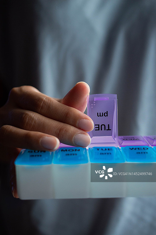 一位东南亚妇女拿着药盒图片素材