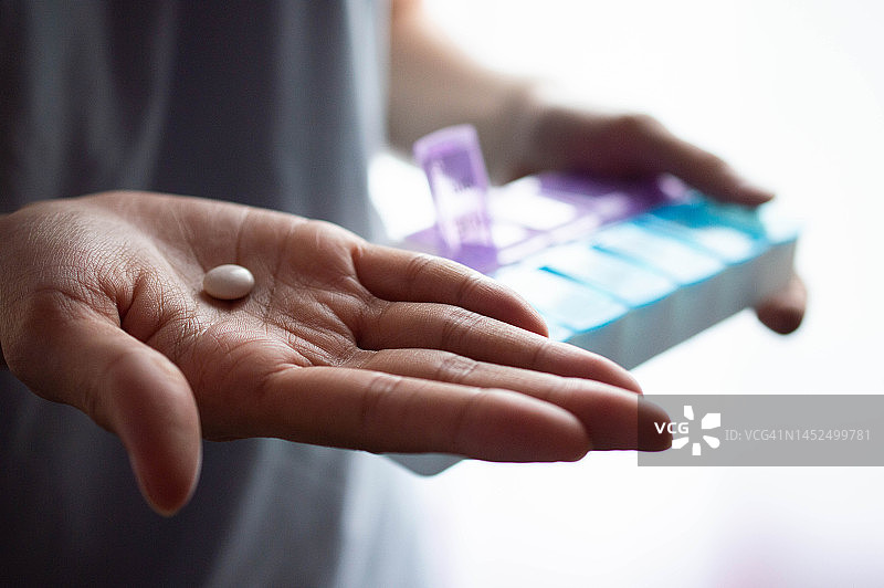 一位东南亚妇女拿着药盒图片素材