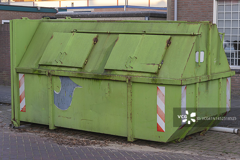 住宅楼前的绿色工业垃圾箱图片素材