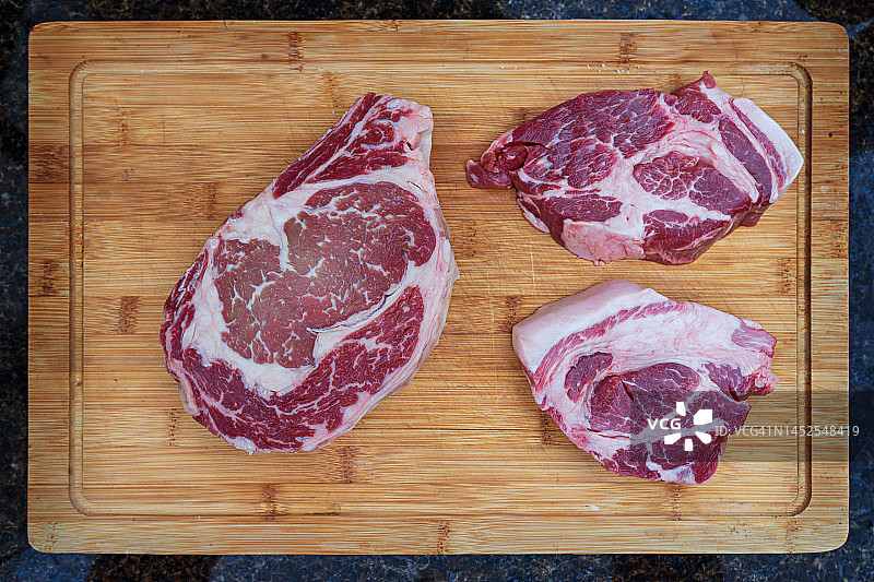 肋眼肉和猪颈肉牛排在砧板上图片素材