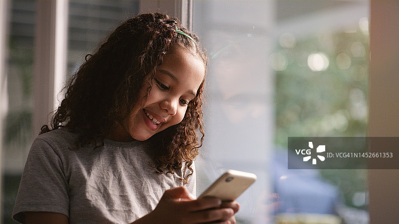 女孩在家发短信或上网，使用手机和社交媒体图片素材