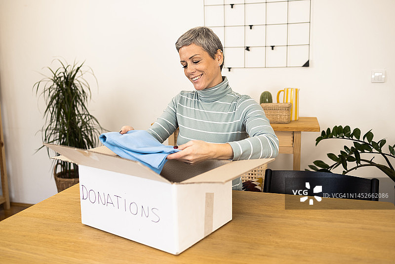 快乐的女人准备一些慈善捐款图片素材