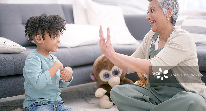 手、游戏和祖母与孩子在地板上玩耍，客厅里的亲情和乐趣图片素材