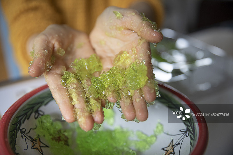 儿童手中拿着压扁的绿色果冻特写图片素材