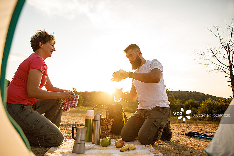 男人在金色时光野餐时与母亲一起提供柠檬水图片素材