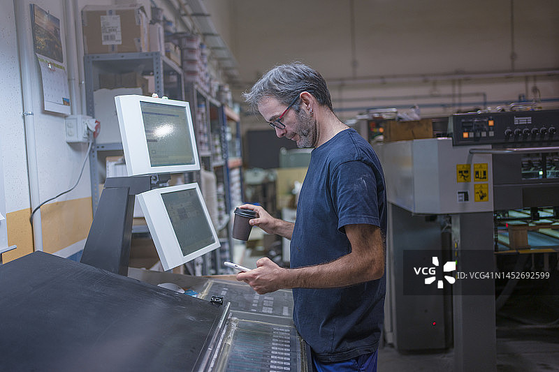掌上印刷：胶印机操作员用手机控制流程图片素材