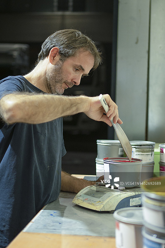 印刷厂的印刷机操作员正在称量油墨图片素材