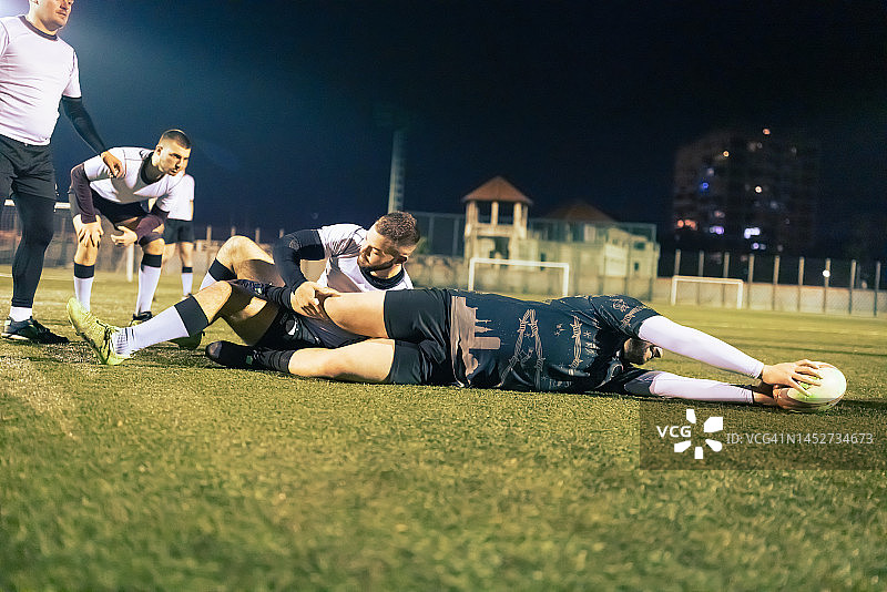橄榄球队傍晚训练：拦截图片素材