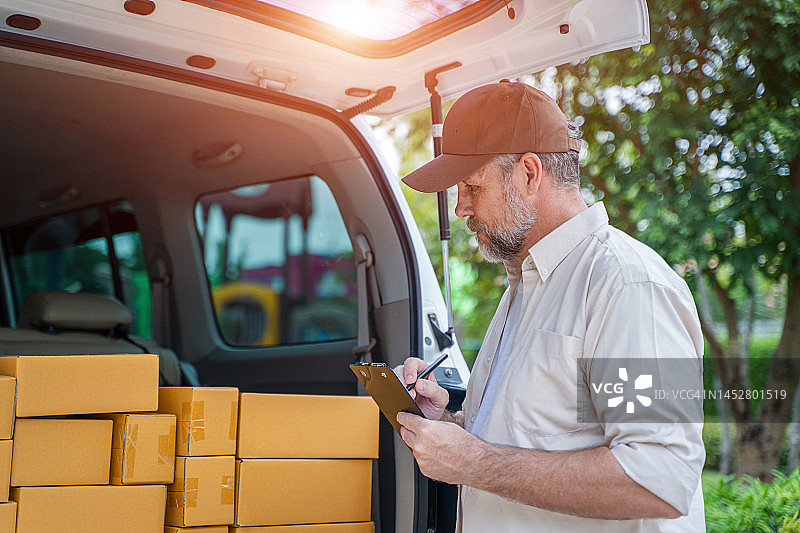 快递员正在检查运送给客户的包裹图片素材