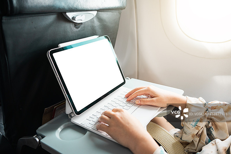 在飞机上使用平板电脑的女商人图片素材