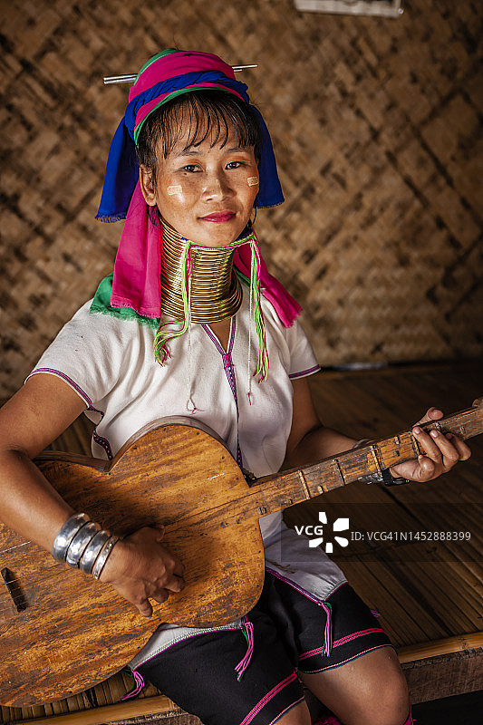 来自泰国北部克伦族长颈族的年轻女子在弹吉他图片素材