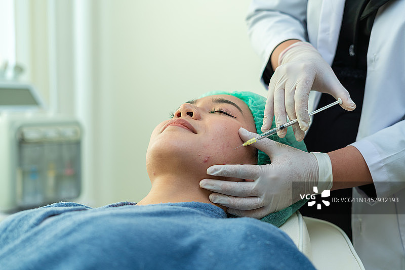 年轻女子在美容院接受面部肉毒杆菌注射图片素材