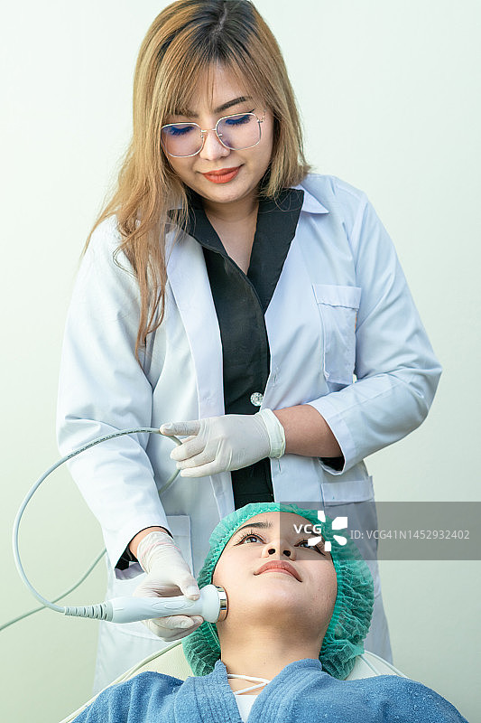 女士在美容诊所接受医生专业治疗的垂直构图图片素材