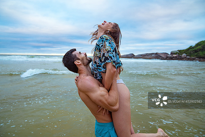 年轻情侣在海滩上共度美好时光图片素材