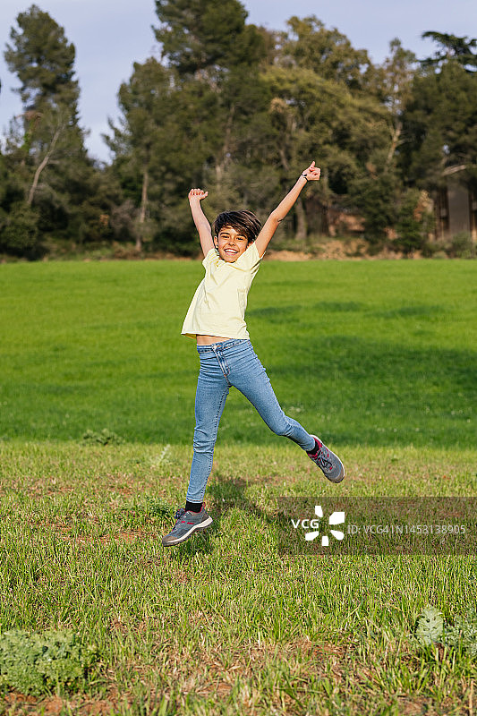 快乐的白人女孩在田野里跳跃图片素材