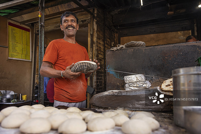 路边餐厅厨师在泥炉中制作烤饼图片素材
