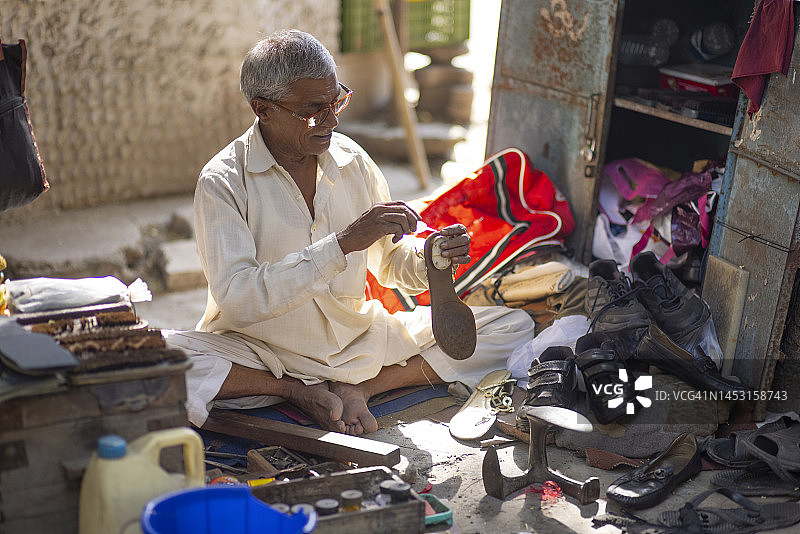 德里街头鞋匠修鞋图片素材