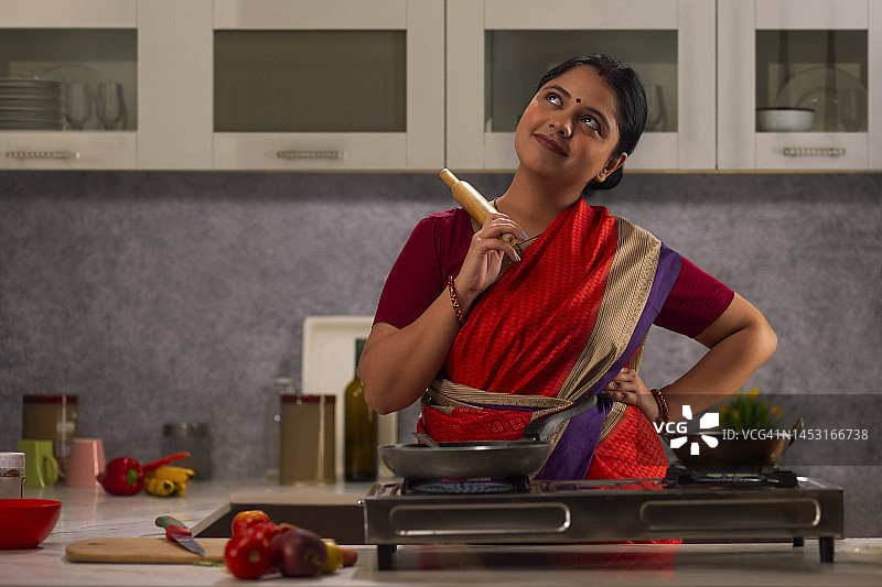 手持擀面杖向上看的正在做饭的女人图片素材