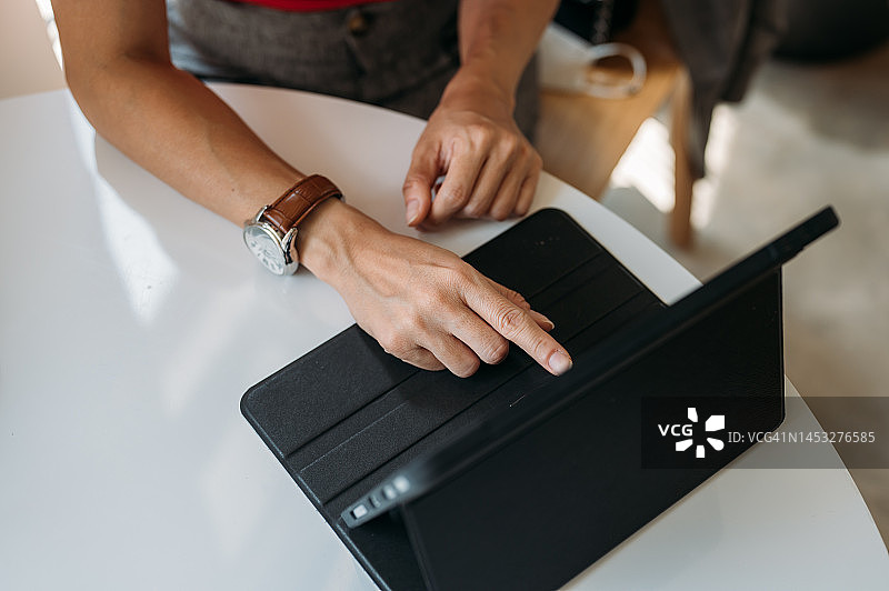 在咖啡店使用平板电脑和笔记本电脑工作的商务女性图片素材