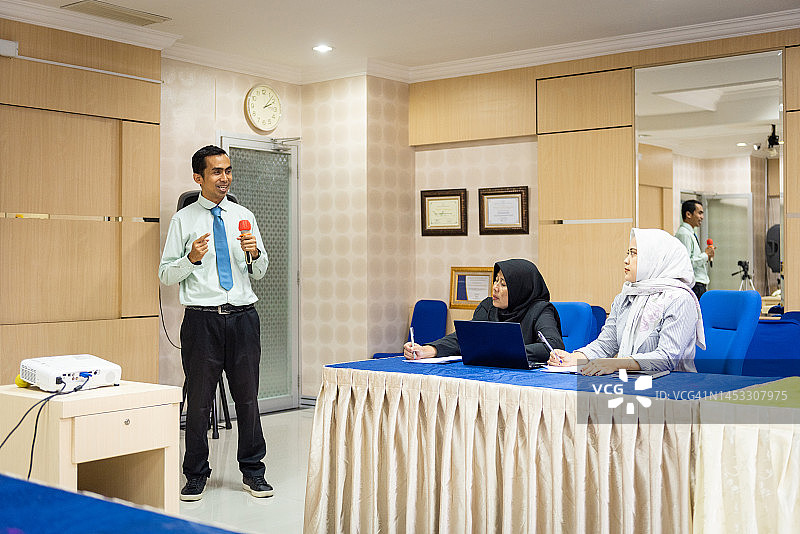 商务人士在办公室会议上做报告图片素材