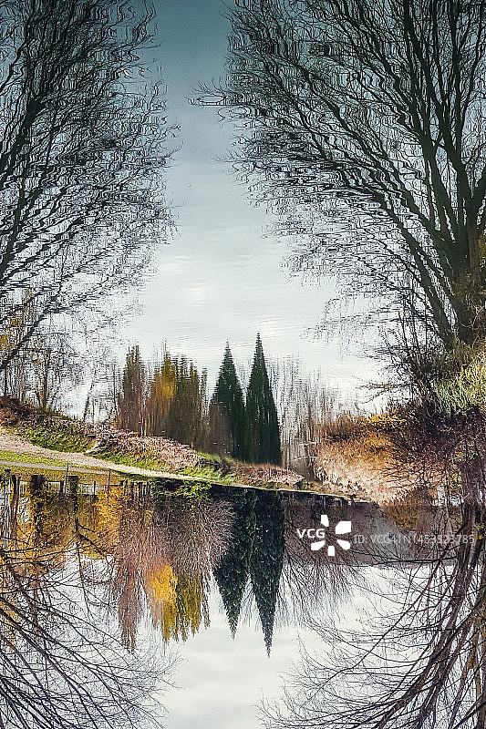 静谧河流中树木的梦幻倒影图片素材