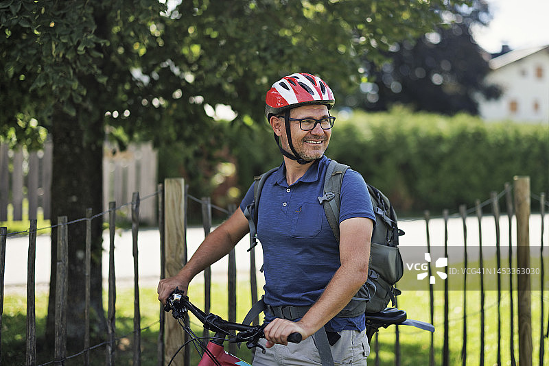 中年男人在奥地利小镇的公园里骑自行车图片素材