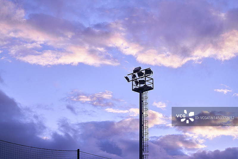 日落时分，云层下的金属体育场反光塔（无人）图片素材