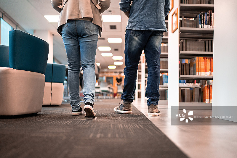 学生在大学图书馆行走的下半身视角图片素材