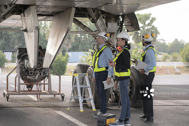地勤人员在机场修理飞机和检查起落架图片素材