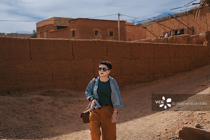 中国女性独自旅行者在北非摩洛哥艾本哈杜古城漫步图片素材
