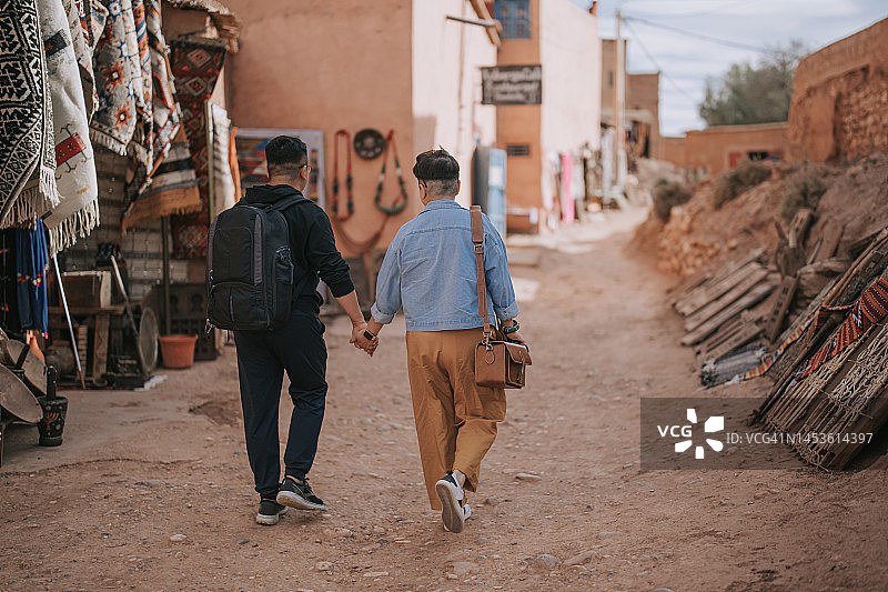 一对亚洲情侣在摩洛哥北部非洲艾本哈杜古城的巷子里行走图片素材