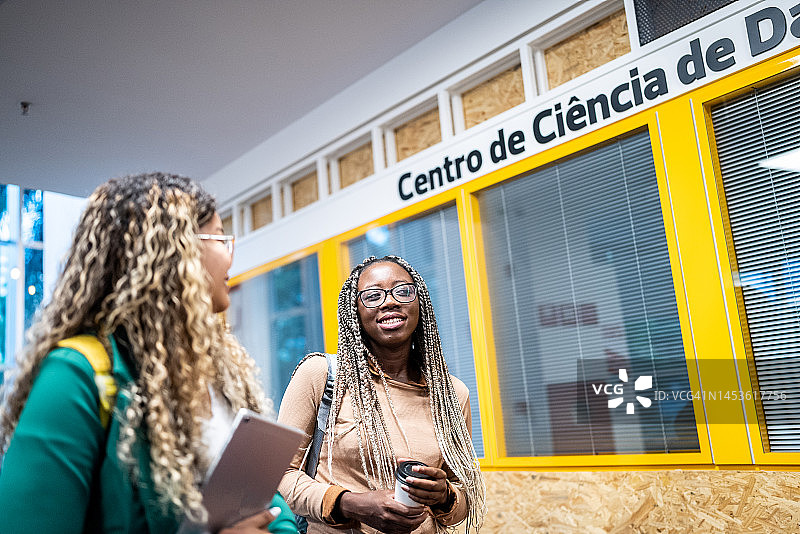 女学生在大学走廊里交谈图片素材