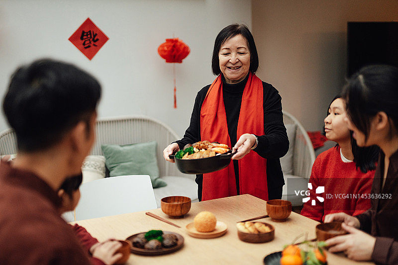 快乐的亚裔三代同堂在餐厅团聚，在家庆祝中国新年图片素材
