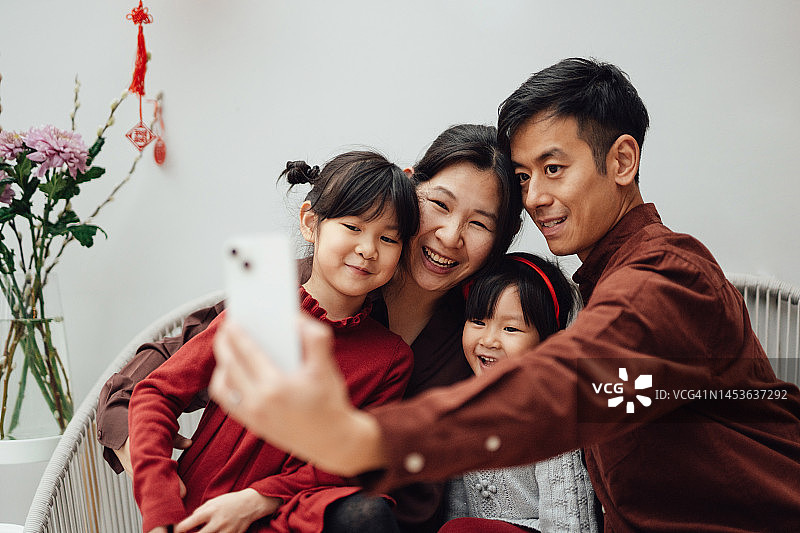 快乐的家庭春节期间用智能手机视频通话图片素材