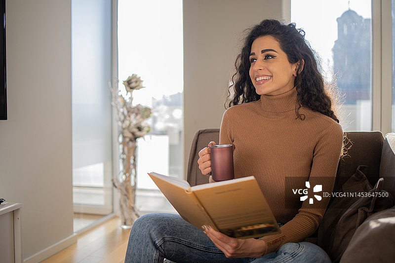 快乐的女人在家看书图片素材