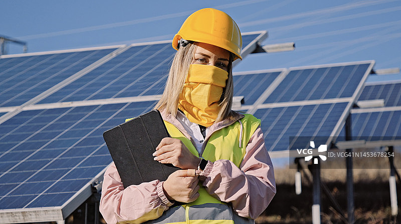 太阳能发电厂中的女工程师肖像。太阳能城市。图片素材