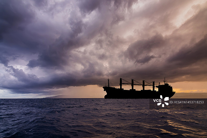 暴风雨天气中海上的货船。物流和货物运输图片素材