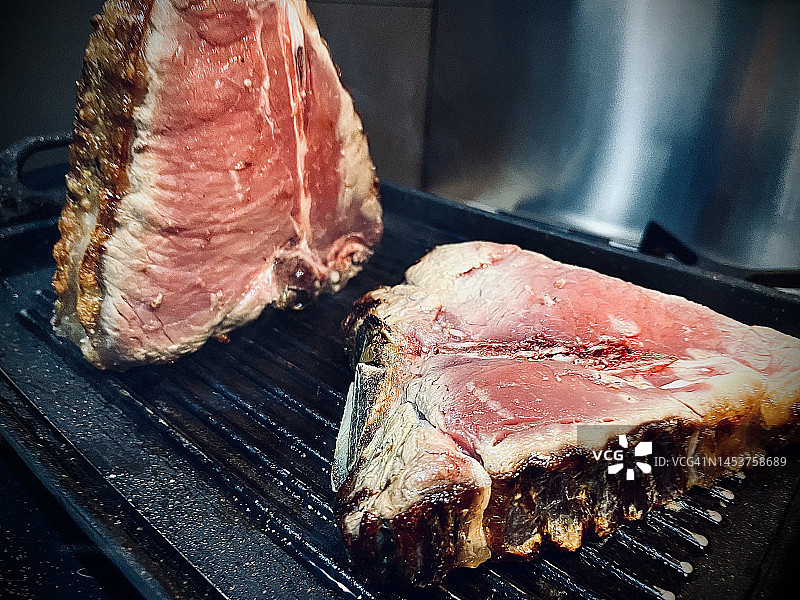 烤架上烹饪的T骨牛排图片素材