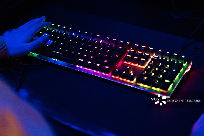 RGB灯光游戏键盘旁的手图片素材
