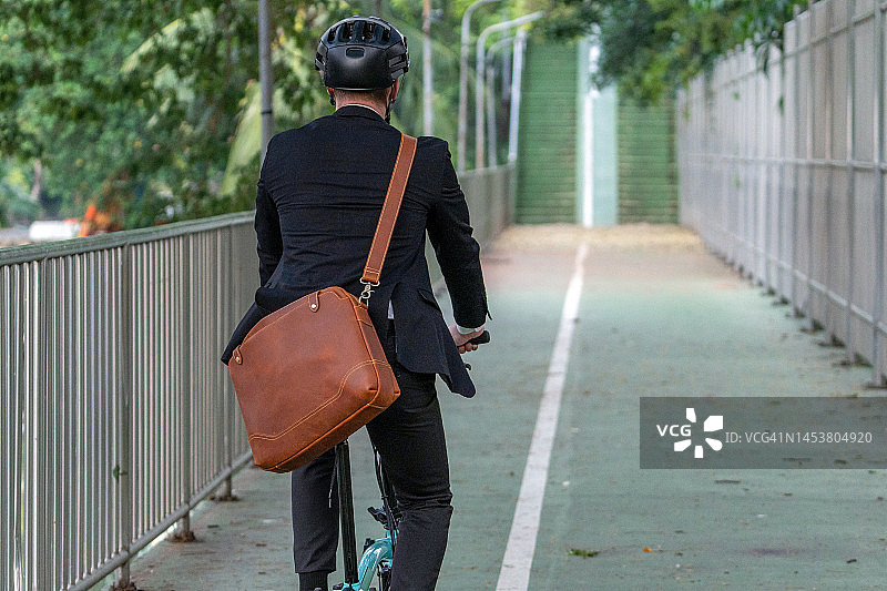 骑电动自行车上下班的商务人士图片素材