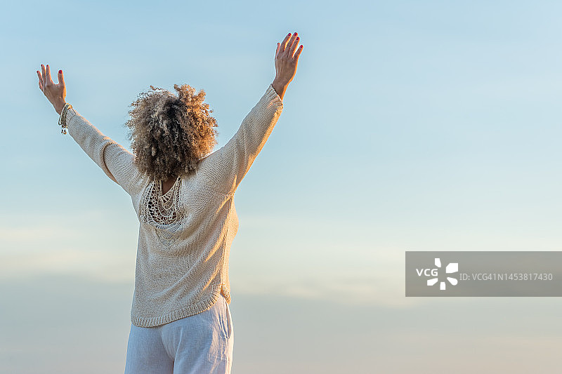 举起双臂的无忧无虑的黑人妇女图片素材