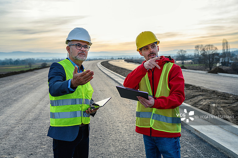 工程师与投资者在道路施工现场图片素材