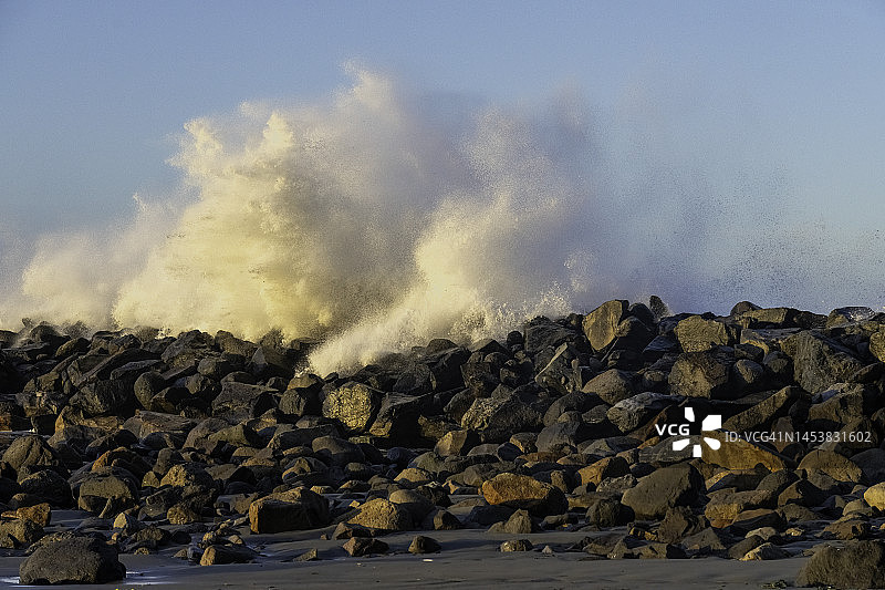 日出时分，海浪拍打着莫罗湾港口码头，美国加利福尼亚州圣路易斯奥比斯波县莫罗湾图片素材