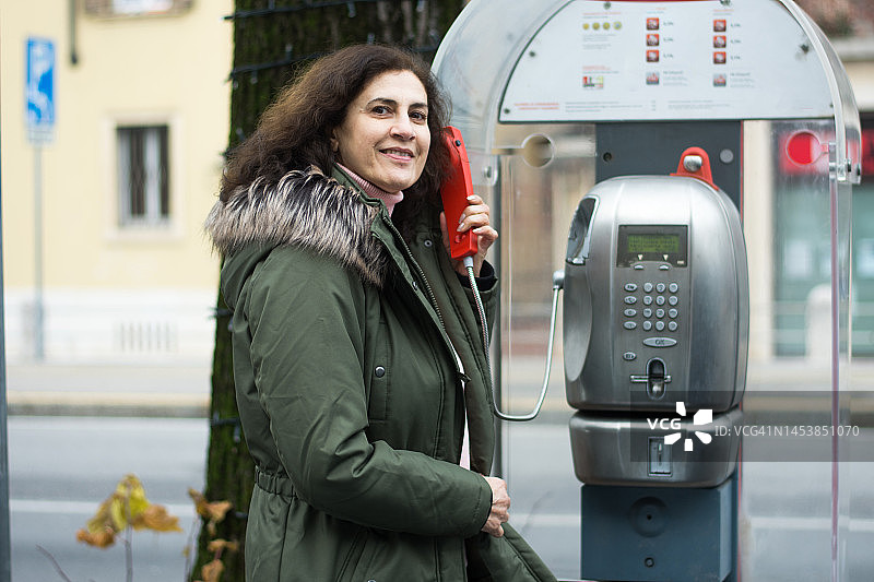 中年妇女在电话亭里图片素材