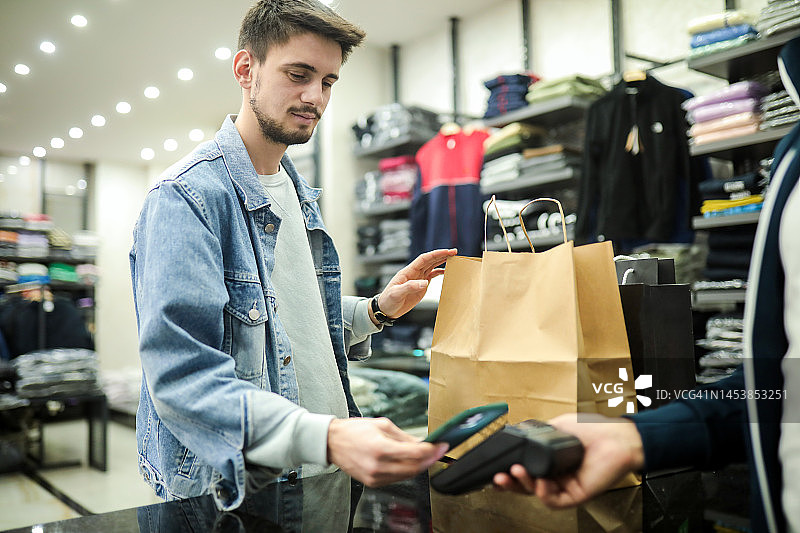 非接触式支付，进行支付，商店购物，日常购物，男士生活方式图片素材